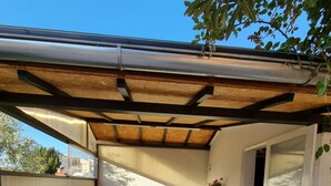 An outdoor patio area with wooden benches and a covered section.