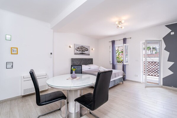 Een moderne slaapkamer met een bed, een nachtkastje en een raam met gordijnen.