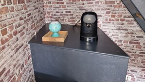 A coffee machine on a black countertop with a brick wall background. - House 7 pers (Fos-sur-Mer)