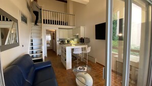 Un intérieur moderne comprenant un escalier, un coin repas et un espace salon.