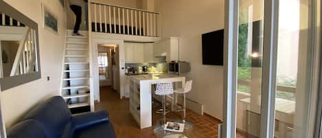 A modern interior with a staircase, a dining area, and a seating area.