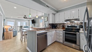 Una cocina moderna con armarios blancos, electrodomésticos de acero inoxidable y una isla grande.