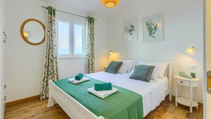 A bedroom with a bed, two bedside tables, a mirror, and a window with curtains. - Villa Serenity - Silence, view and heated pool by MyWaycation (Supetar)