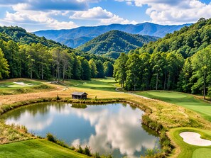 Un parcours de golf avec un étang, des arbres et des montagnes en arrière-plan.