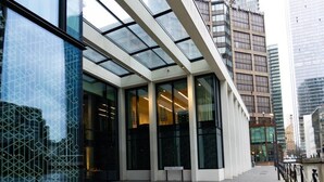 Ein modernes Gebäude mit großen Glasfenstern und einem gepflasterten Weg.