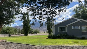 A modern house with a well-maintained lawn and a view of mountains. - Beautiful Monroe Home on Paiute trail by Mystic Hot Springs ATV, flyers landing (Monroe)