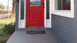 A red door with a glass panel and a welcome mat. - Beautiful Monroe Home on Paiute trail by Mystic Hot Springs ATV, flyers landing (Monroe)