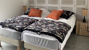 A double bed with a headboard, two bedside tables, and a hanging light fixture. - 10 min from the beach and 5min from the town center (Propriano)
