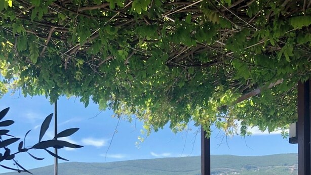 An outdoor dining area with a table set for two, overlooking a coastal landscape with hills and a body of water. - The Bay Panoramic Views (5 min from the beach) - perfect for (Herceg Novi)