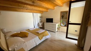A bedroom with a bed, a TV, a dresser, and a window. - The First Flower (Noto)