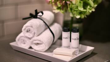 A tray with two rolled white towels, two bottles of Babor Energizing Lime & Green Tea, and a bar of soap.