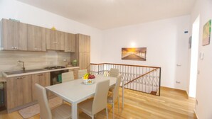 A modern kitchen with wooden cabinets and a dining area with a table and chairs.