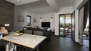 Un salon moderne comprenant un coin repas, un téléviseur à écran plat et un balcon avec vue.
