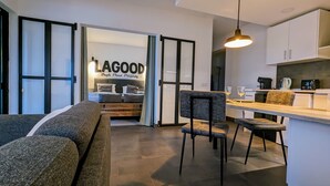 Un intérieur moderne comprenant un canapé, des fauteuils, un coin repas et une cuisine.