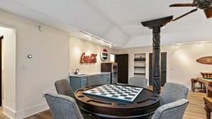 A dining area with a round table, chairs, and a checkered game board. - Beachfront Villa, Panoramic Deck & Private Beach (Ponte Vedra Beach)