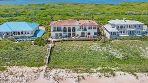 A beachfront property with multiple buildings, a dock, and a view of the ocean. - Beachfront Villa, Panoramic Deck & Private Beach (Ponte Vedra Beach)