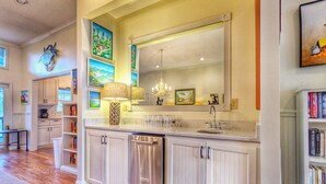 A kitchen with white cabinetry, a stainless steel refrigerator, a large mirror, and a bookshelf filled with books. - Private Pool - Litchfield Beach - Second Row (Pawleys Island)