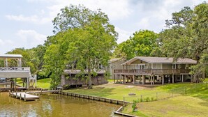 A lakeside property with a dock, a covered pavilion, and a two-story house with a deck. - Creek Front Home w/ Fishing Pier & Amazing Outdoor Spaces (Sargent)