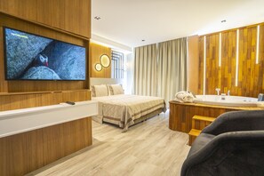 A modern hotel room with a large bed, a TV mounted on the wall, a wooden vanity with a sink, and a large window with curtains. - Antalya City Hotel & Spa (Antalya)