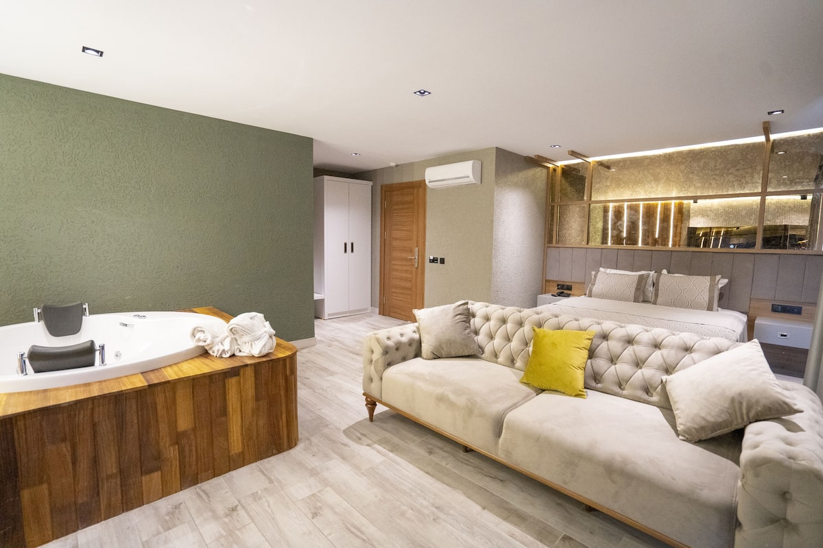 Een moderne slaapkamer met een groot bed, een houten kaptafel en een ingebouwd bad.
