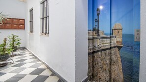 A hallway with a checkered floor, a potted plant, and a wall-mounted mailbox. - Cadiz Meridian Apartment (Cádiz)