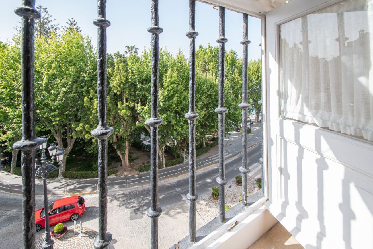 Un balcón con vista a una carretera y árboles.