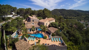 A villa with a swimming pool, outdoor seating, and a view of the surrounding landscape. - Manor House at Masia Nur Sitges ( adults only, very stylisch)  ) (Canyelles)
