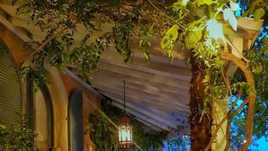 An outdoor patio area with a pergola, seating, and potted plants. - Manor House at Masia Nur Sitges ( adults only, very stylisch)  ) (Canyelles)