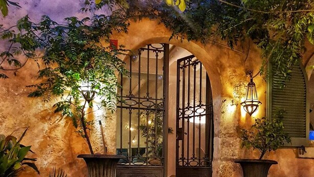 A stone staircase leading to a gated entrance with potted plants and a wrought iron gate. - Manor House at Masia Nur Sitges ( adults only, very stylisch)  ) (Canyelles)