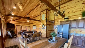 Ein Holzblockhaus-Interieur mit Essbereich, Küche und Wohnzimmer.