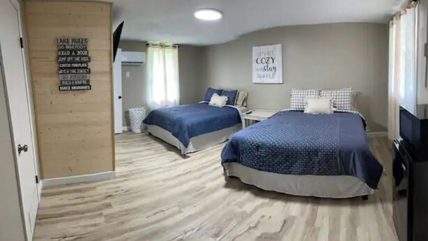 Une chambre d’hôtel avec deux lits, une télévision et un panneau indiquant les règles à respecter.