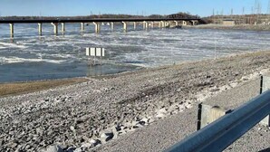 Une rivière avec un pont en arrière-plan.