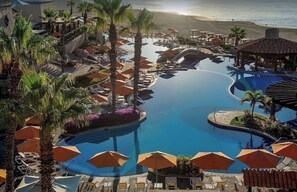 Relax by the resort's central pool surrounded by lounge areas and lush tropical plants.