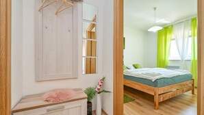 Un dormitorio con una cama de madera, una mesita de noche, un espejo y un armario.