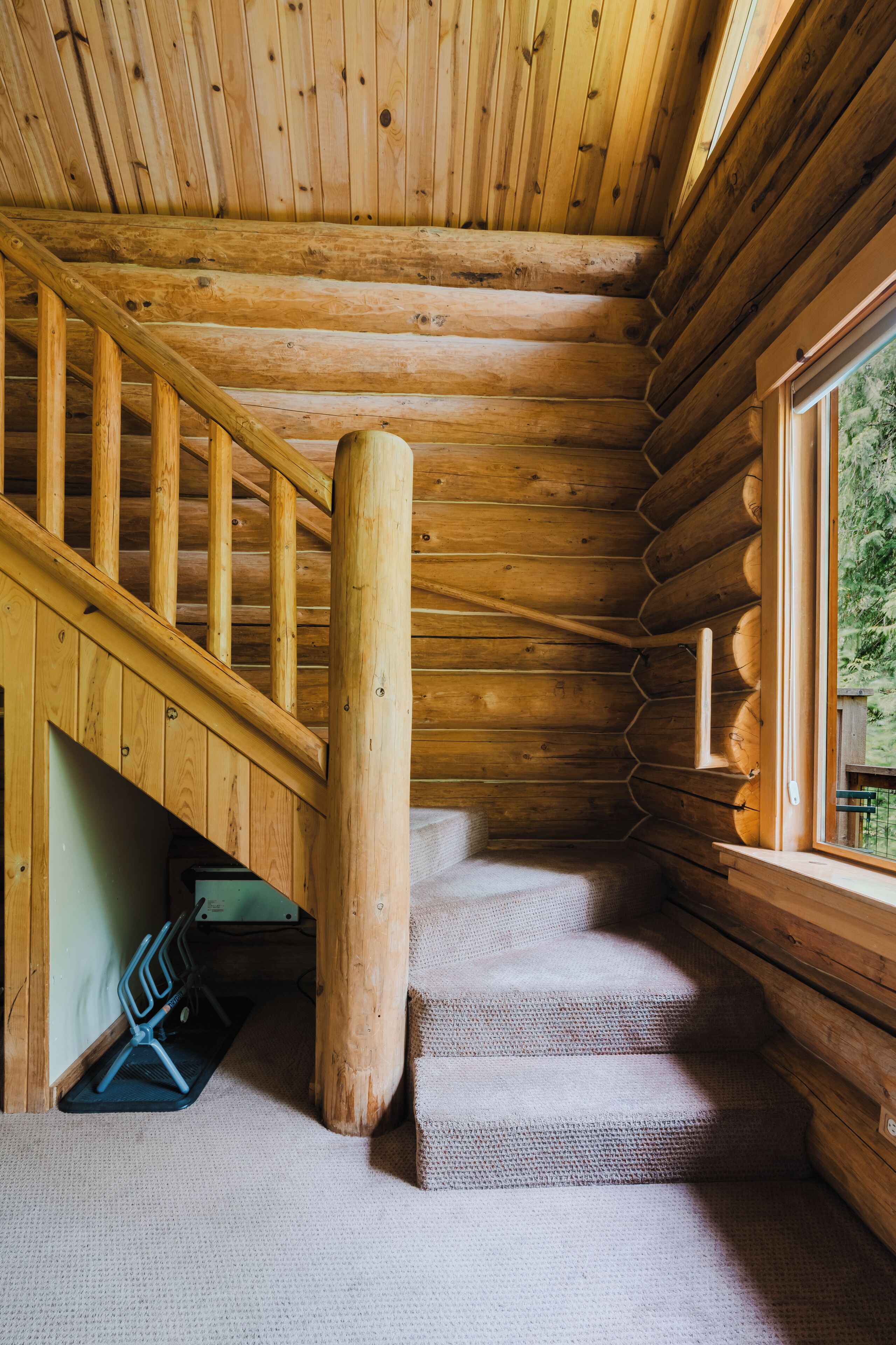 A wooden staircase with a handrail leading to a landing.