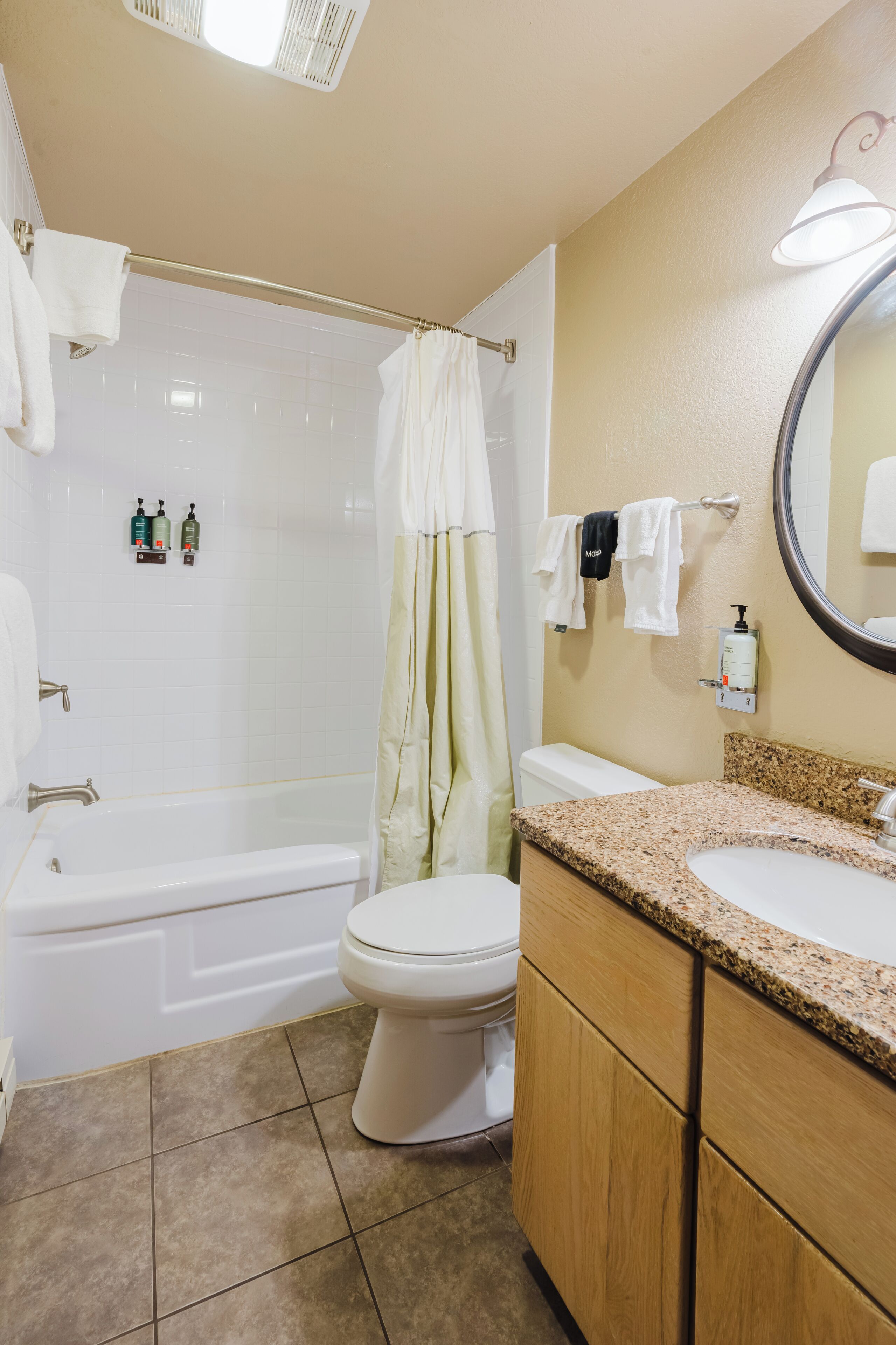 A bathroom with a bathtub, toilet, sink, and a shower curtain.