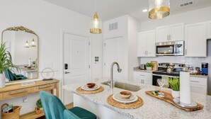 A modern kitchen with white cabinets, a stainless steel stove, and a granite countertop.