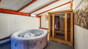 Ein Spa-Raum mit Whirlpool, Holzschrank und Steinwand.