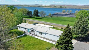 Une maison de plain-pied avec un garage, une véranda et une vue sur un lac.