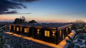 A modern, rectangular building with a flat roof, multiple windows, and a well-lit exterior. - Awesome home in Knebel with sauna (Knebel)
