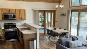 Una cocina amplia con armarios de madera, una isla grande y un comedor con mesa y sillas.