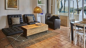 A living room with a sofa, ottoman, coffee table, and a dining area with a table and chairs.
