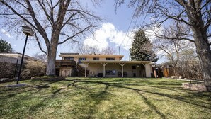 A two-story house with a covered porch and a fenced yard. - Basecamp Denver 2BR Guest Suite near Red Rocks (Lakewood)