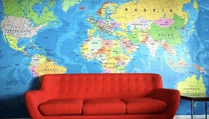Un sofá rojo frente a un mapa mundial.