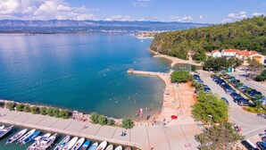 Zona costera con puerto deportivo, playa y edificios residenciales.