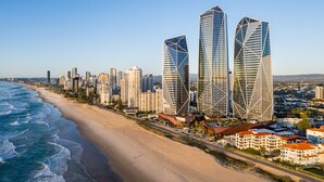 A coastal cityscape with modern high-rise buildings, a sandy beach, and a clear blue sky. - The Langham, Gold Coast and Jewel Residences (Surfers Paradise)
