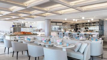 A modern restaurant with a high ceiling, seating areas, and a visible kitchen area.