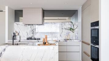 A modern kitchen with marble countertops, built-in appliances, and a minimalist design.