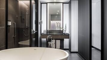 Un baño moderno con una bañera independiente, una ducha con cerramiento de vidrio y un tocador con espejo.
