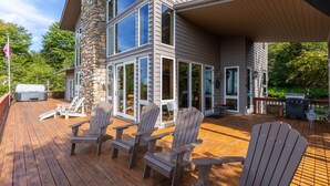 A multi-story house with a wooden deck, stone pillar, and large windows. - Skytop Chateau at The Summit of Beech - Incredible 50+ Views! Game Room! (Beech Mountain)